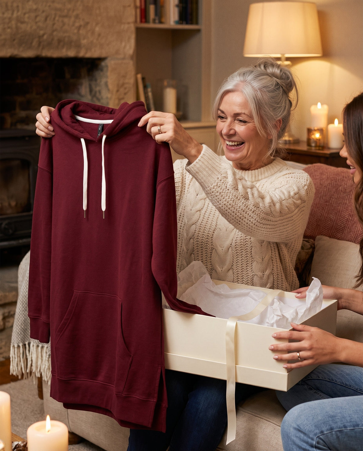 Woman delighted as she unwraps the burgundy Junemae hoodie dress, a gift for her