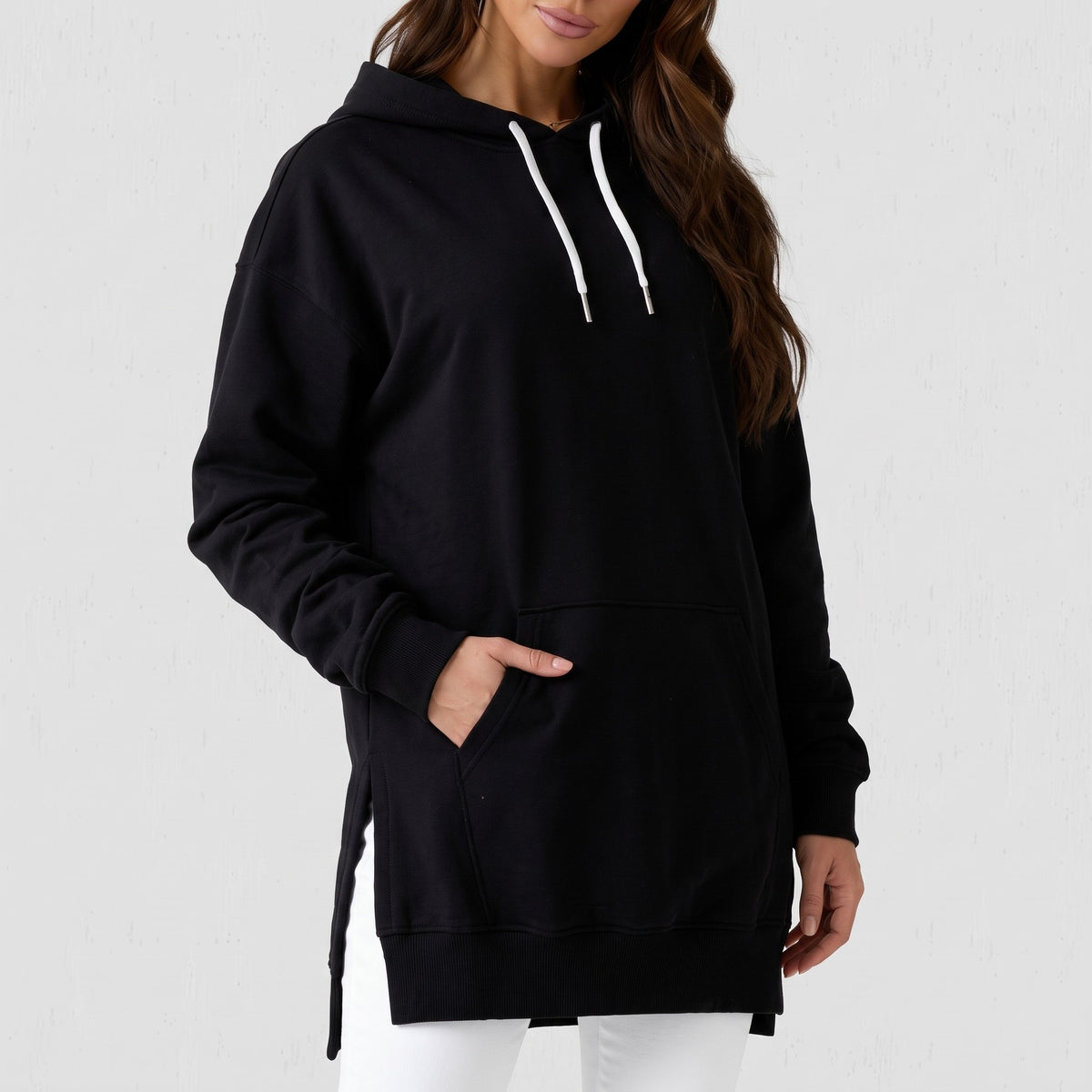 Details of the black hoodie dress: drawstrings with metal tips, kangaroo pocket and side slit