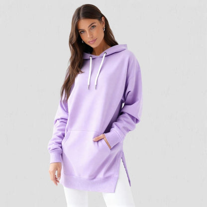 Woman wearing the Junemae oversized hoodie dress in lavender, with side slits and a kangaroo pocket