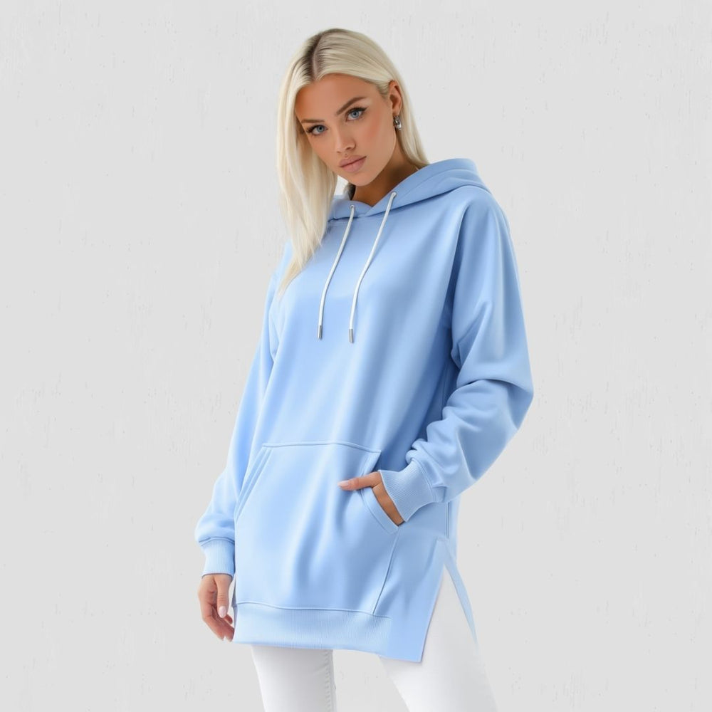 Woman wearing the Junemae oversized hoodie dress in sky blue, with side slits and a kangaroo pocket